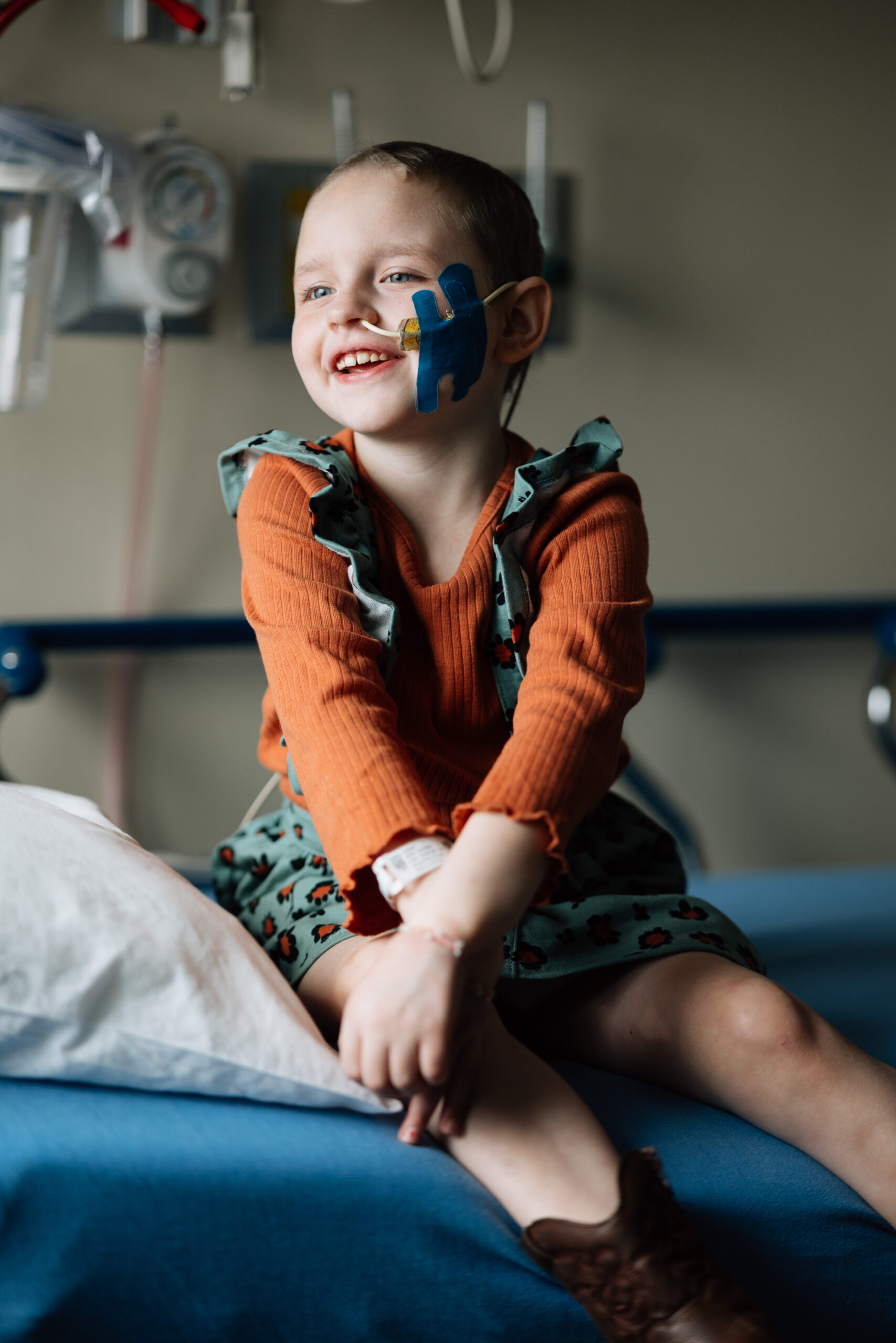 little girl in hospital bed smiling